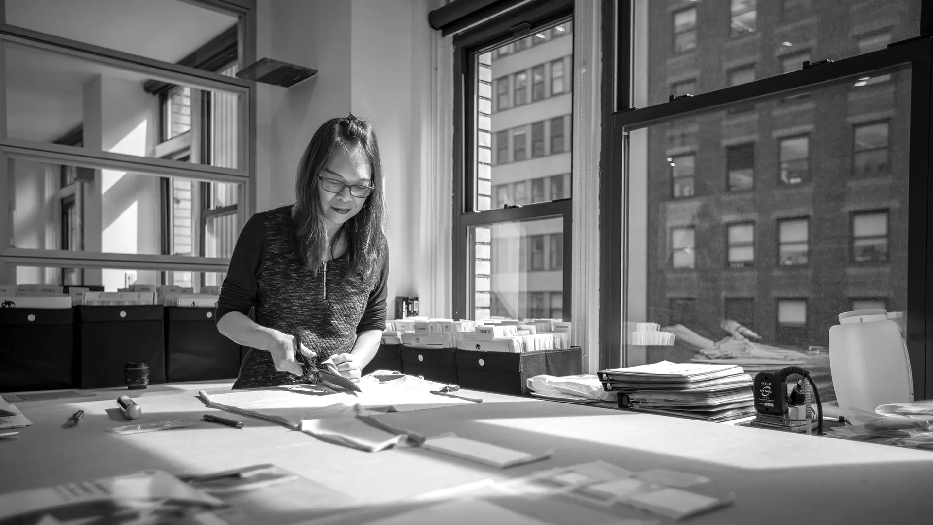 Couturière coupant tissu photographiée en noir et blanc pour communication corporate PME artisan Côte d'Azur